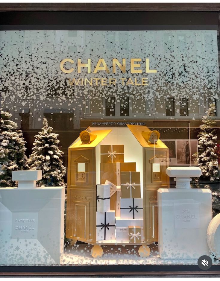Vitrine de Noël enneigée, coffrets dorés et sapins blancs